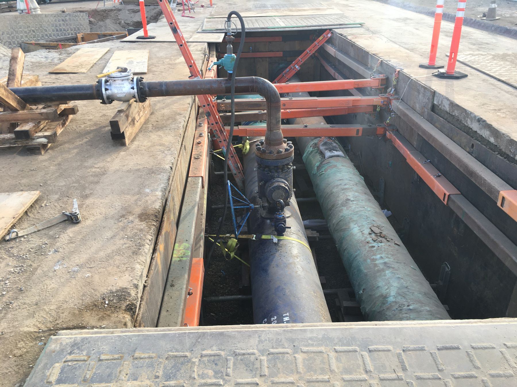 Existing pipelines and valves exposed in a shored excavation